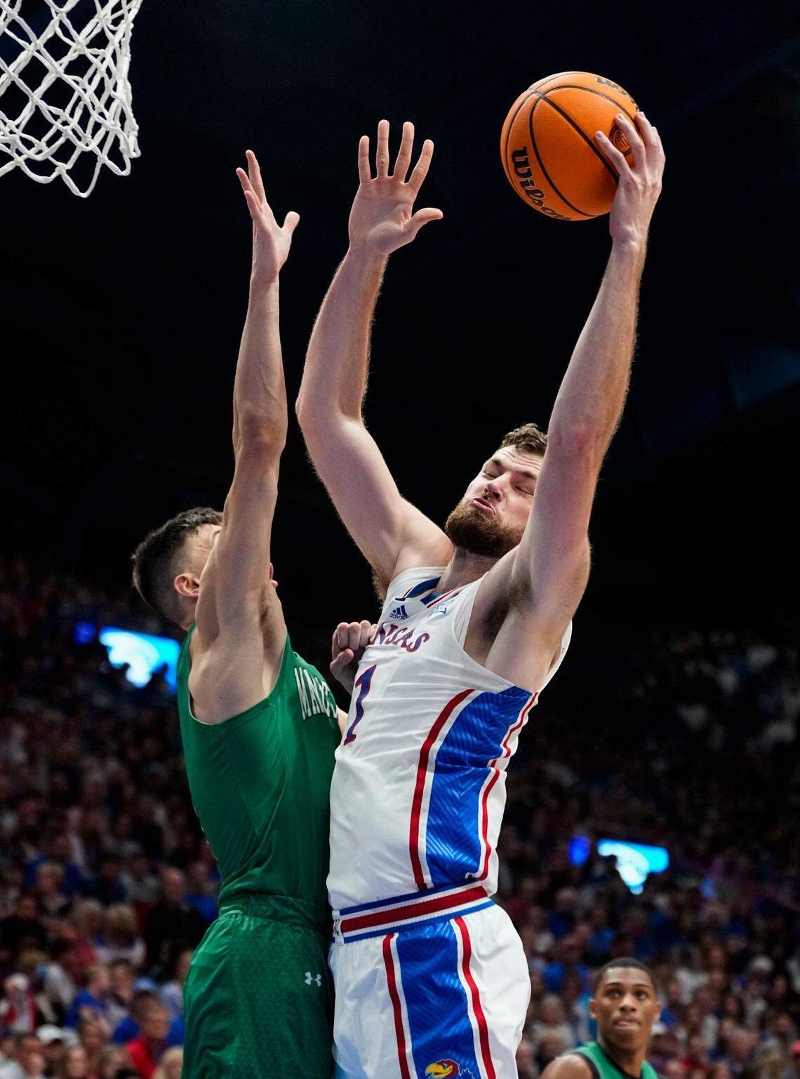 Kansas Jayhawks center Hunter Dickinson shoots around Manhattan Jaspers guard Brett Rumpel during Friday night’s game at Allen Fieldhouse.