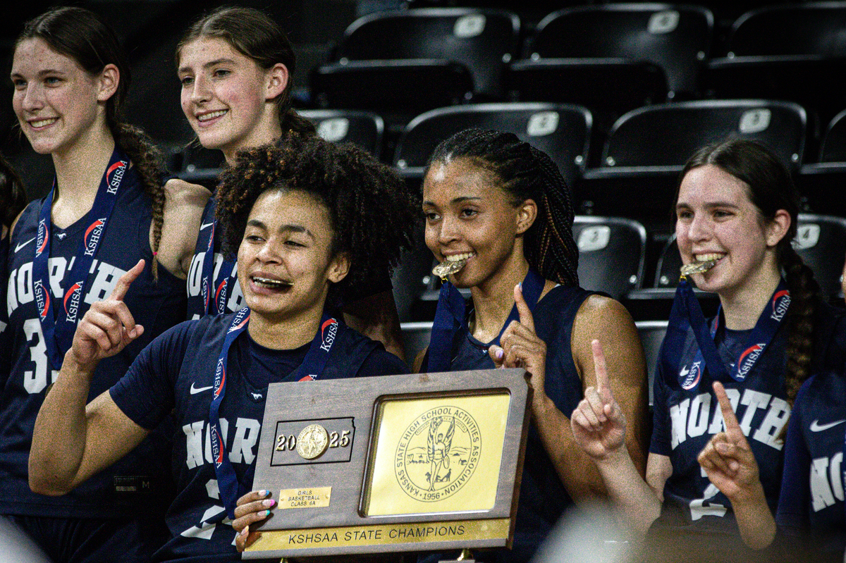 Jaliya Davis (left) and Aubrey Shaw (middle) celebrate with teammates after Blue Valley North won its second Kansas Class 6A state title in three seasons on Saturday, March 15, 2025.