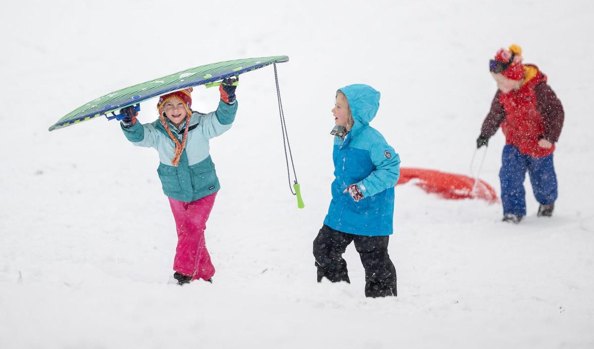 Hannah Sorensen, 6, left, walks up the Brookside Hill with Sonja Sifton, 7, while sledding on Tuesday, Jan. 9, 2024, in Kansas City.