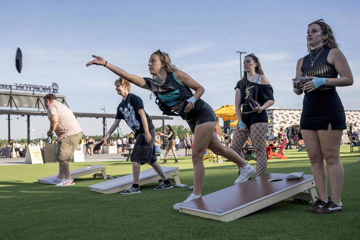 Visitors play cornhole before Kesha's Freedom Tour concert at the Morton Amphitheater on Wednesday, June 3, 2026, in Riverside.