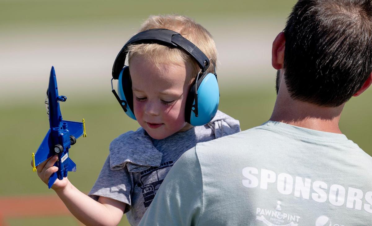 A child plays with a replica F/A-18 Hornet, the same fighter jet flown by the U.S. Navy Blue Angels, during the Garmin KC Air Show on Saturday, Aug. 19, 2023, in New Century.
