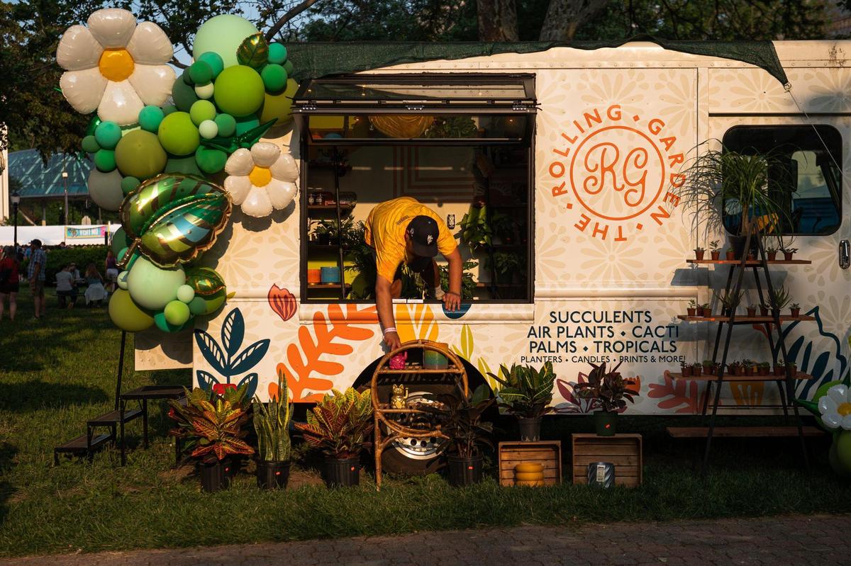 Owner of The Rolling Garden, Tyree Nelson, fixes a display in front of his truck at Boulevardia on Friday, June 16, 2023, in Kansas City. Nelson was one of 52 different local vendors whose work was featured at the festival.