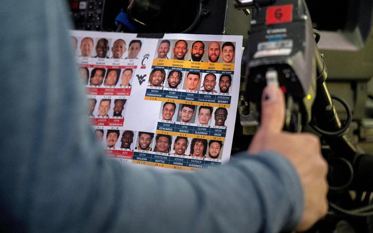 The camera operator keeps a roster with photos of the players on the teams playing for quick identification while he covers the game.
