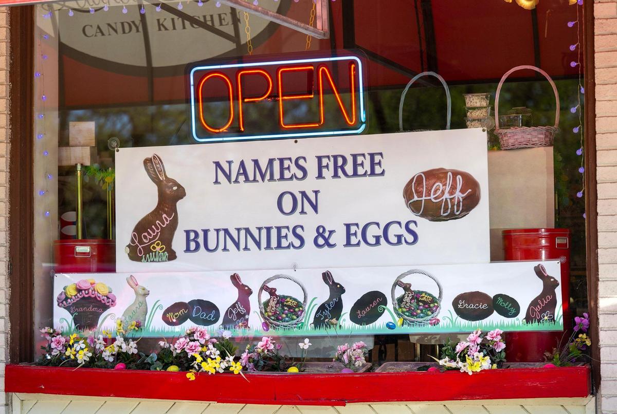 A banner promotes the personalized chocolate Easter bunnies and fudge eggs available at the candy shop.