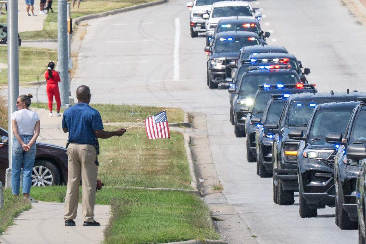 Bystanders along State Avenue watch as police lead a funeral processional for slain KCKPD Officer Hunter Simoncic, on Wednesday, Sept. 3, 2025, in Kansas City, Kansas. Simoncic was killed Aug. 26 after being struck by a fleeing driver while deploying stop sticks.
