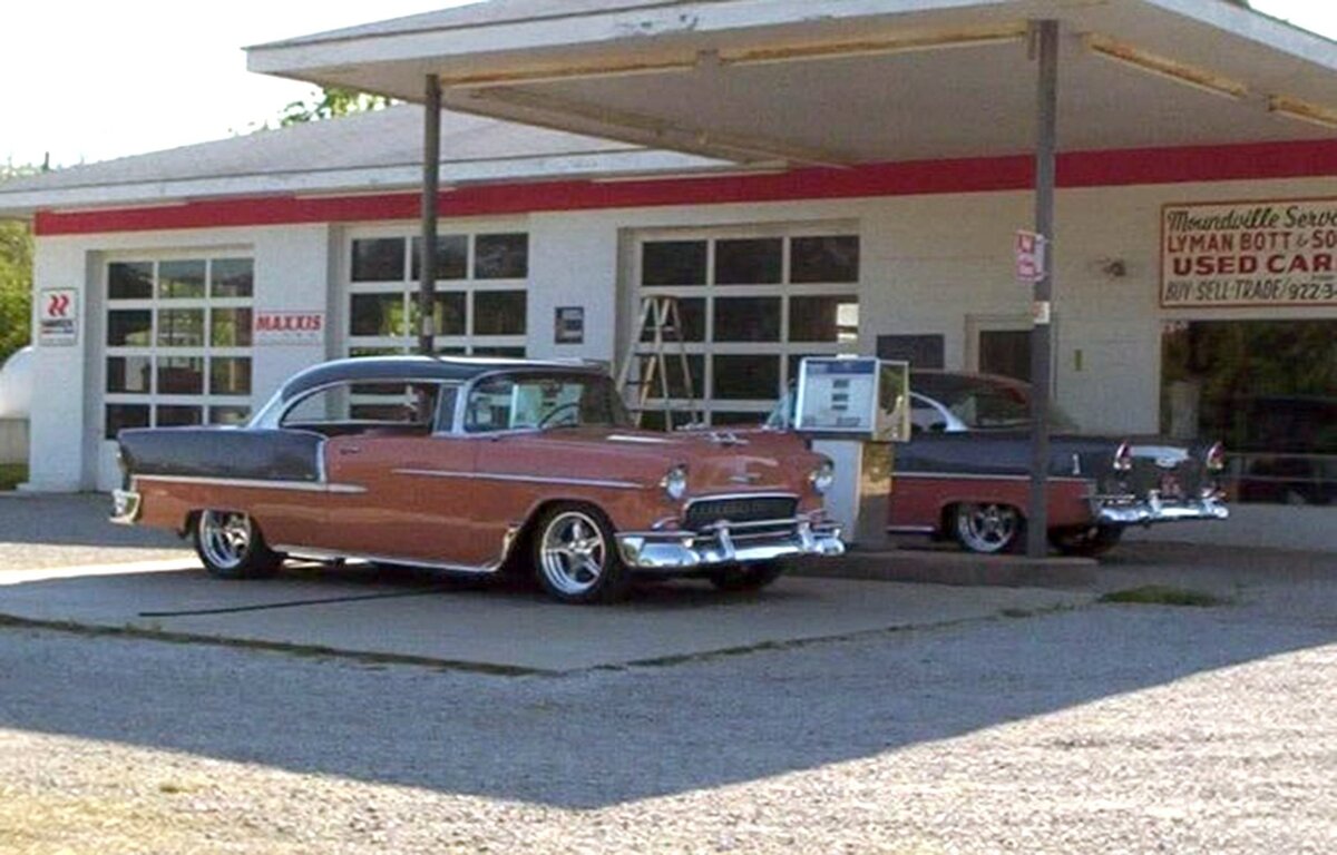 A 2016 family photo shows two vintage cars parked at the Moundville Service Station in Moundville, Missouri.