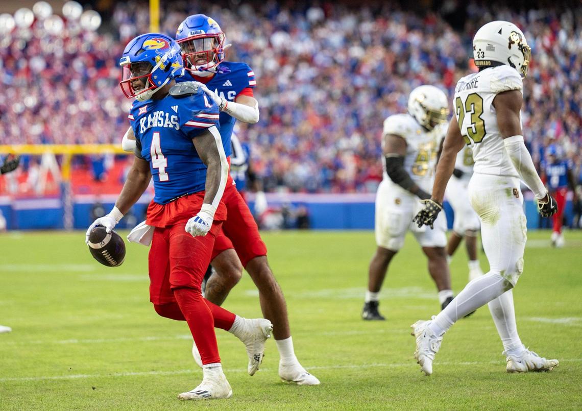 Kansas Jayhawks running back Devin Neal (4) is congratulated by receiver Quentin Skinner (0) after scoring a touchdown during the first half at GEHA Field at Arrowhead Stadium on Saturday, Nov. 23, 2024, in Kansas City.