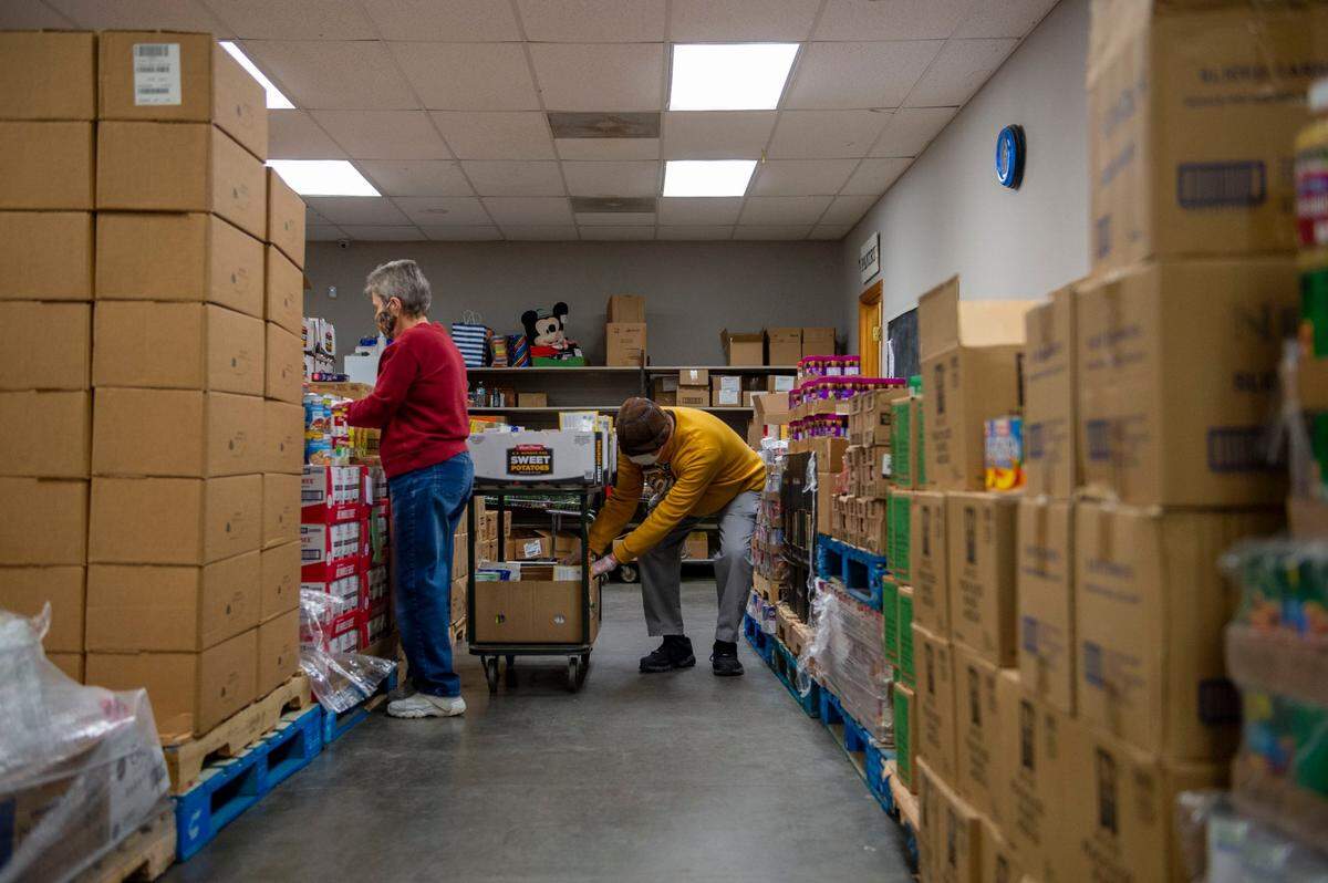 Karen Parker, left, and her husband, Richard Parker, help organize food to be distributed at Open Door food pantry in Sedalia on Dec. 7, 2021.