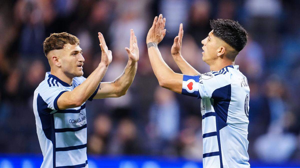 Sporting Kansas City midfielder Marinos Tzionis (77) congratulates forward Alan Pulido (9) after scoring a goal during the second half against Tulsa Athletic at Children’s Mercy Park on April 25, 2023.