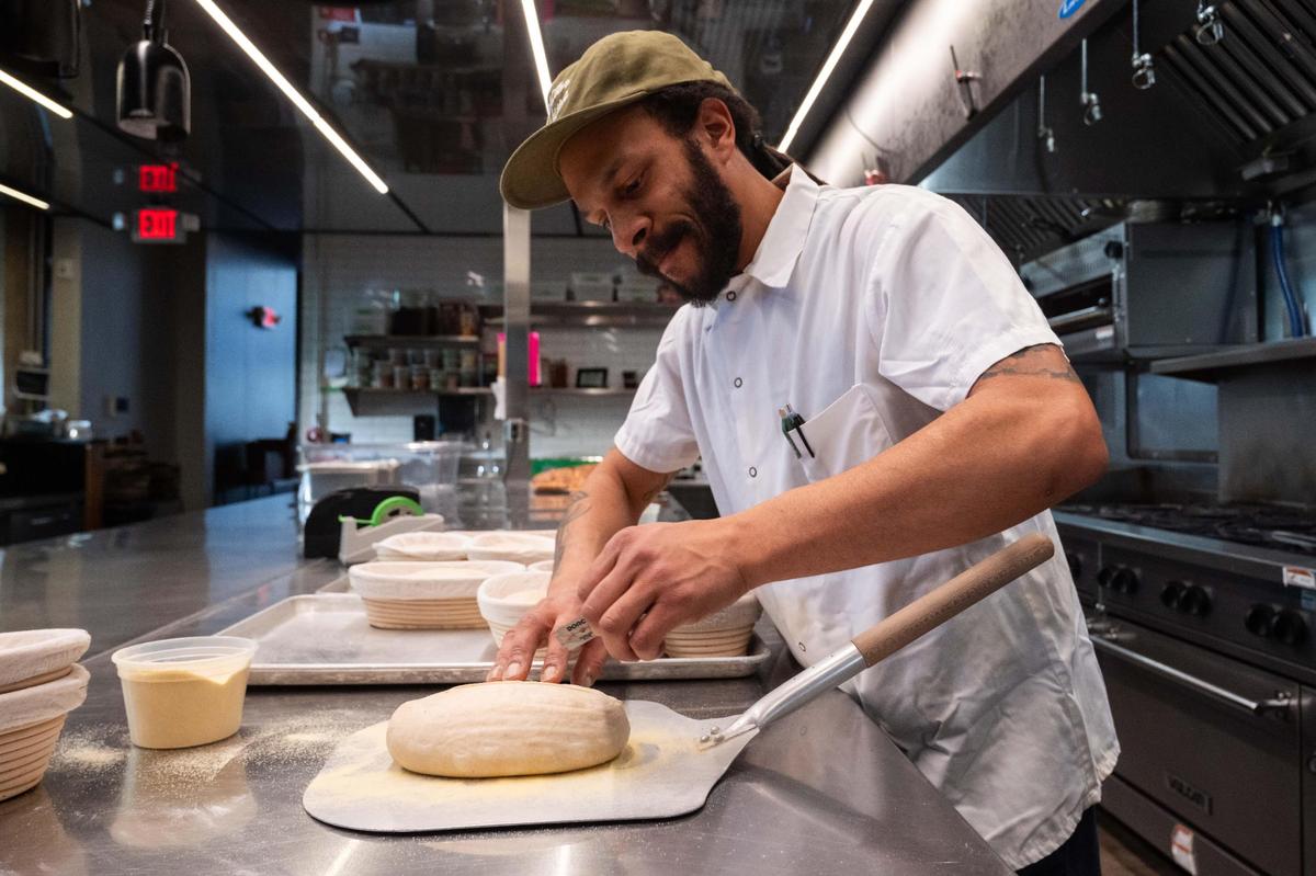 Kendall Harris, lead baker at Green Dirt on Oak, prepares a sourdough loaf for baking on Tuesday.