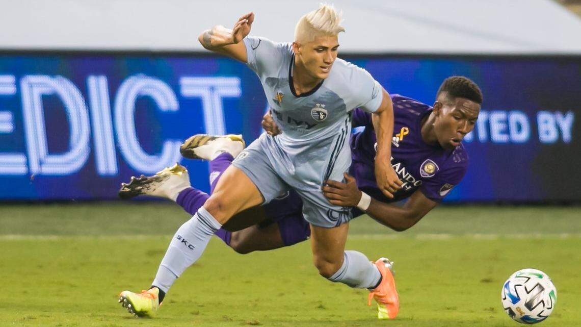Sporting Kansas City forward Alan Pulido is tackled by Orlando City midfielder Andres Perea during a late-September match at Children’s Mercy Park in Kansas City, Kan.