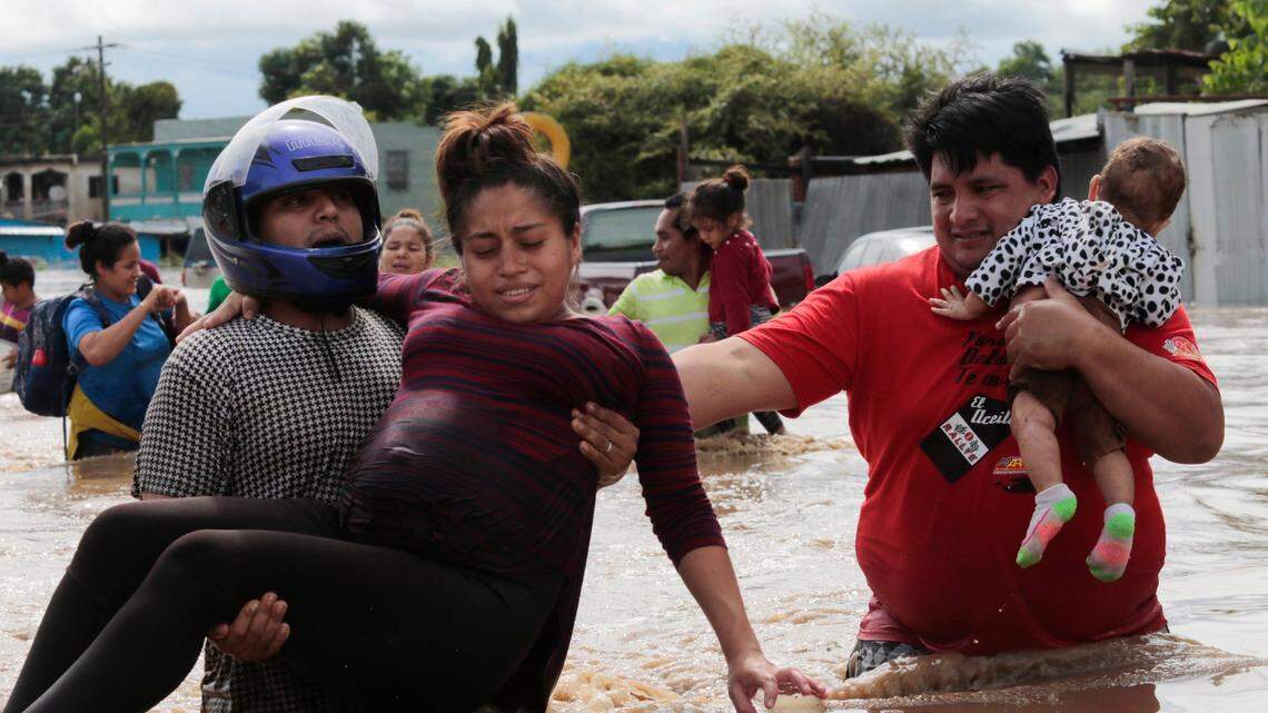 In this Nov. 5, 2020 file photo, a pregnant woman is carried out of an area flooded by water brought by Hurricane Eta in Planeta, Honduras. Thousands of homes were damaged and the infamous gang violence has not relented in Honduras, where some residents said gangs were charging a tax to boats trying to rescue people from flooded neighborhoods.