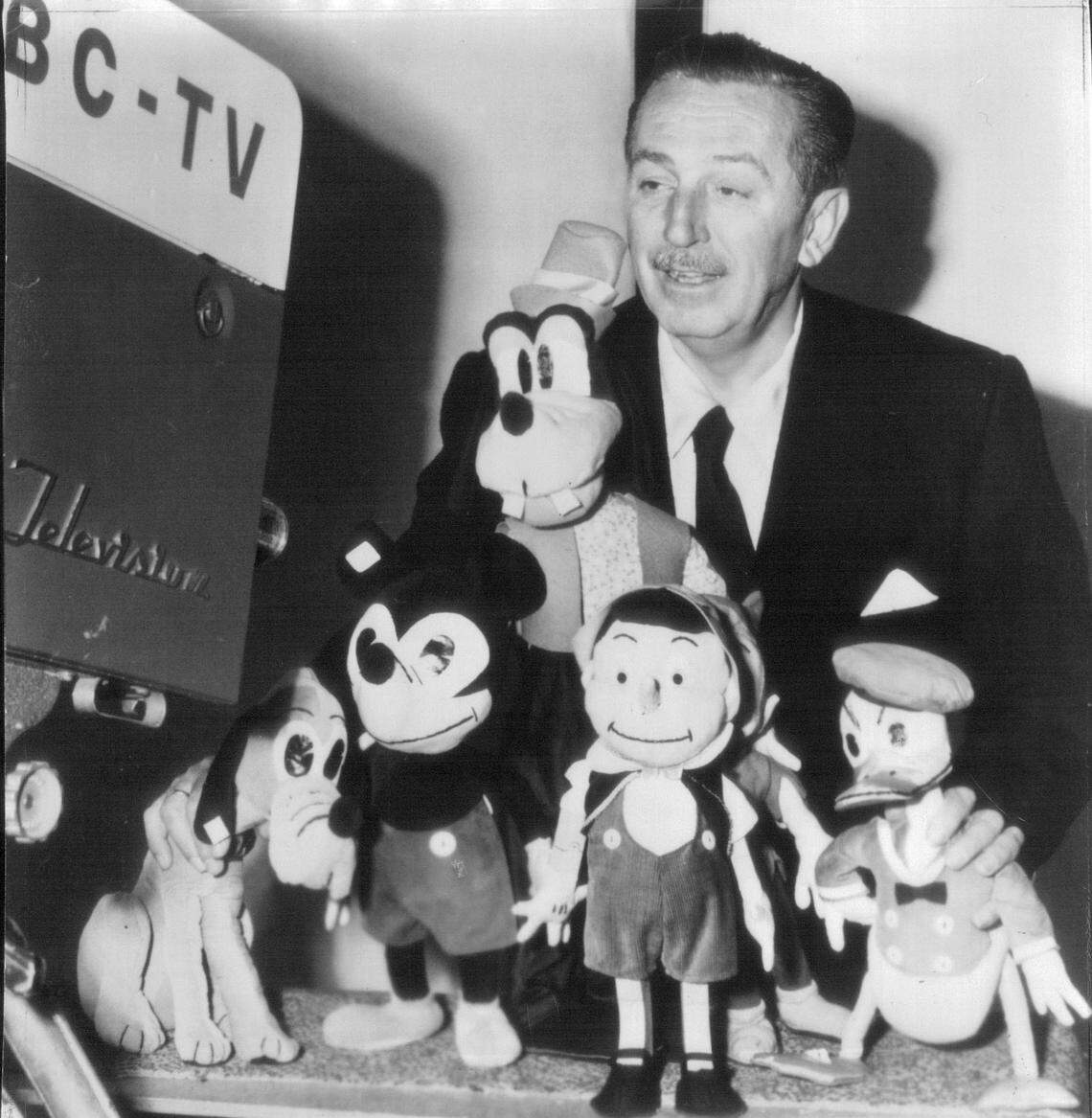 Walt Disney poses with some of his characters in 1954