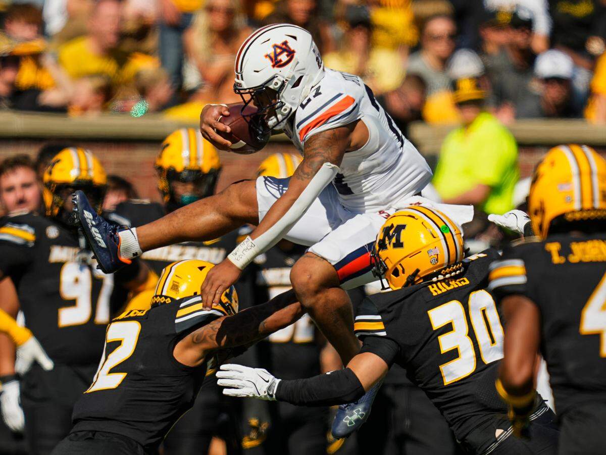Auburn Tigers running back Jarquez Hunter leaps Mizzou’s Dreyden Norwood and Chuck Hicks during Saturday’s game at Faurot Field at Memorial Stadium.