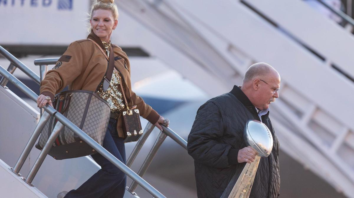 Kansas City Chiefs’ head coach Andy Reid, followed by his wife Tammy, holds the Lombardi Trophy as he steps off the team’s charter plane at Kansas City International Airport on Tuesday.
