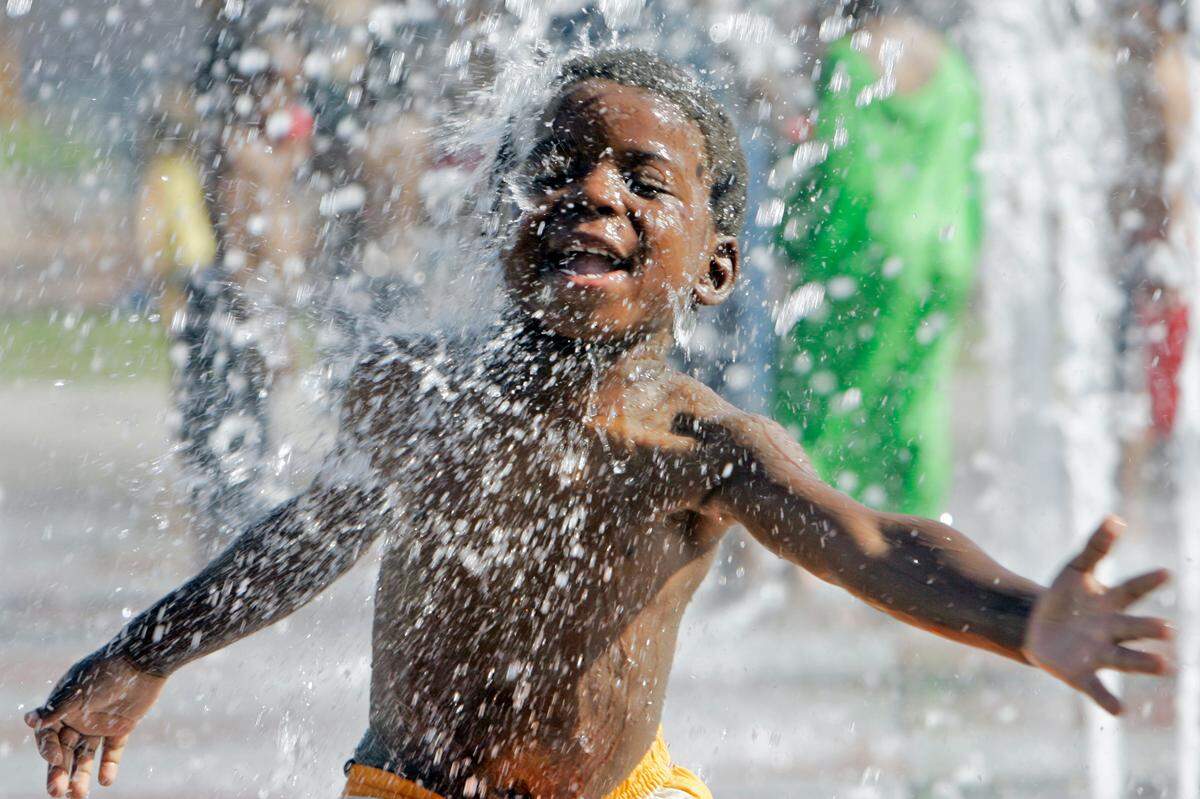 Jamiya Dennis, 4, of Kansas City, reveled in the fountain spray in Crown Center Square. June 18, 2006.