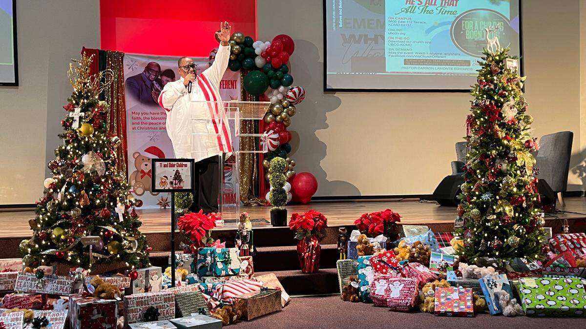 Pastor Darron Edwards addresses the crowd at United Believers Community Church before giving out more than 100 presents to families and children impacted by violence.