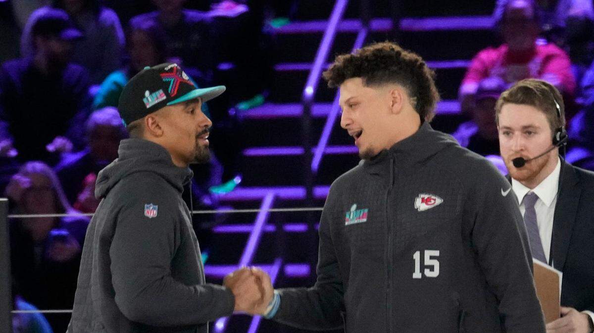 Philadelphia Eagles quarterback Jalen Hurts and Kansas City Chiefs quarterback Patrick Mahomes shake hands on stage at the Footprint Center in downtown Phoenix during the NFL’s Super Bowl Opening Night on Feb. 6, 2023.