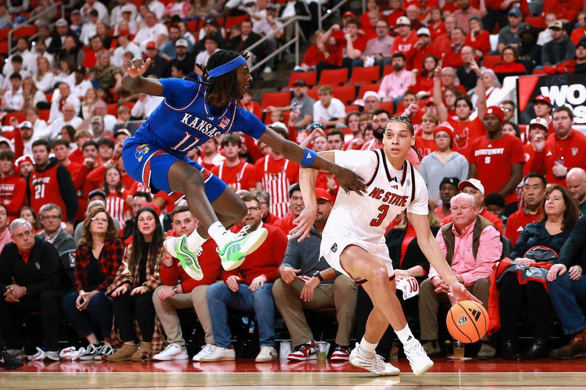 Jamari McDowell #11 of the Kansas Jayhawks defends Matt Able #3 of the NC State Wolfpack during the first half of the game at Lenovo Center on December 13, 2025 in Raleigh, North Carolina.