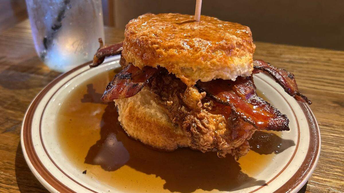 Atomic Cowboy’s “Lola” has fried chicken and bacon sandwiched between two biscuits and drizzled in syrup.