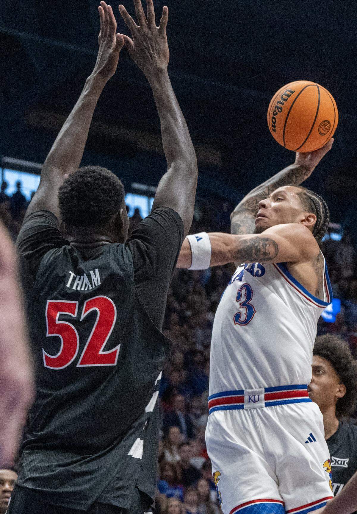 Kansas Jayhawks guard Tre White (3) goes up for a shot as Cincinnati Bearcats center Moustapha Thiam (52) defends in the first half Allen Fieldhouse on Saturday, Feb. 21, 2026, in Lawrence, Kansas.