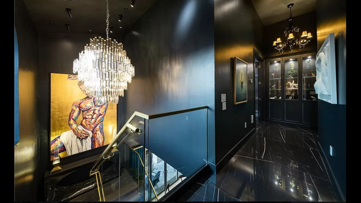 A custom chandelier hangs above the lighted glass staircase inside 4 E. 51st St. Glass cases for display wait at the end of the hallway, and you can take an elevator upstairs.