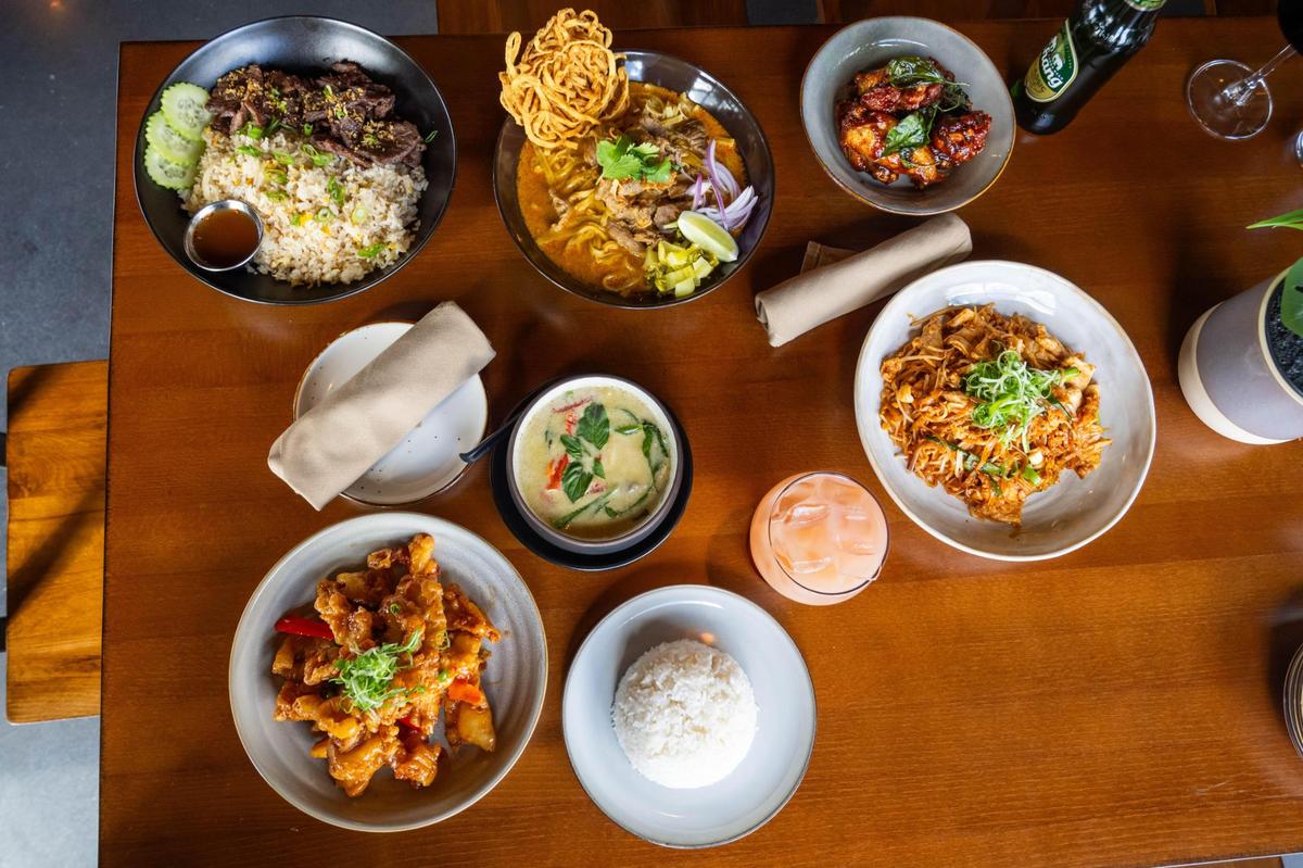 An spread of several main dishes and appetizers offered at Thai Orchid.