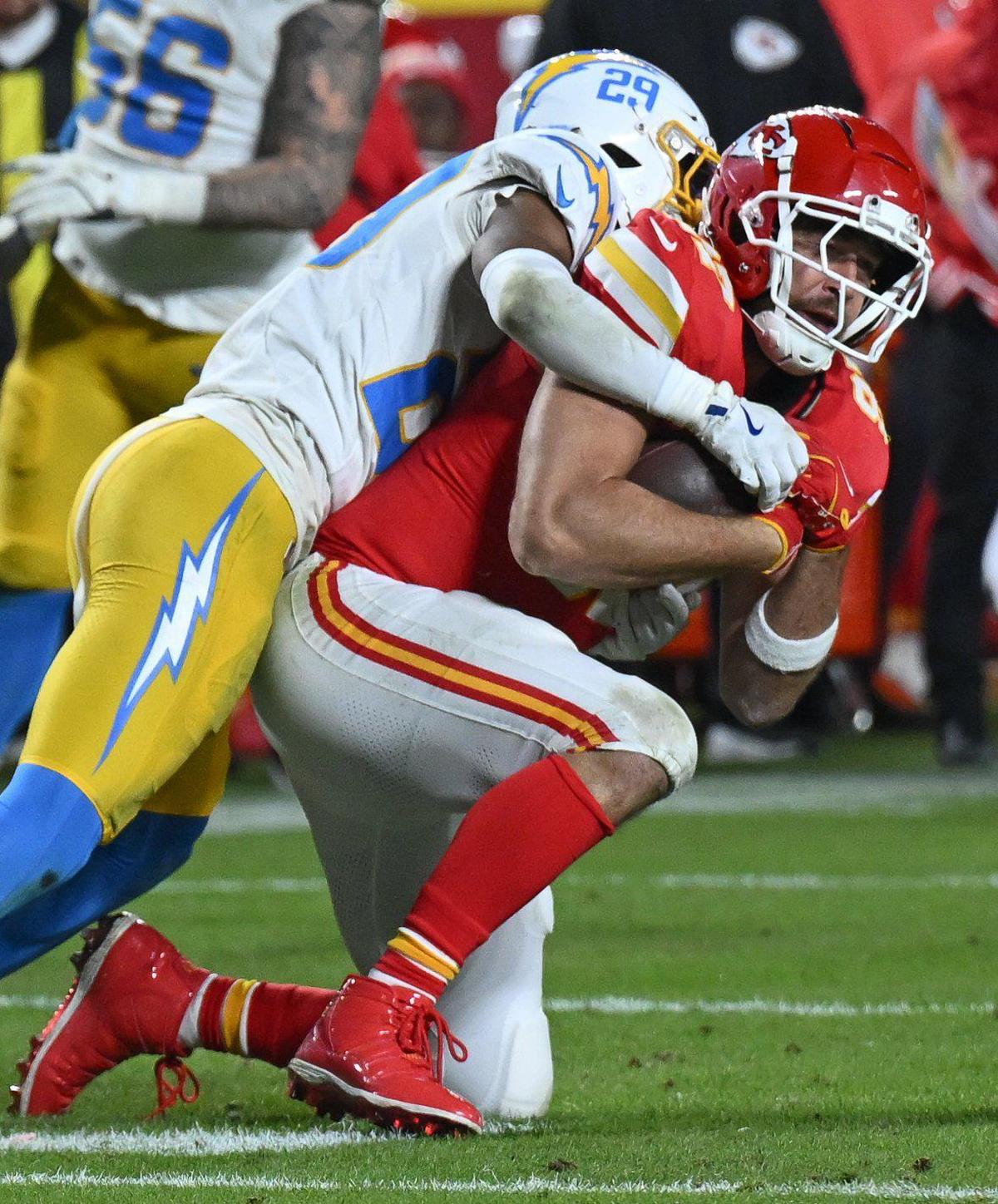 Kansas City Chiefs tight end Travis Kelce (87) makes a catch to get the Chiefs within field goal range before being tackled by Los Angeles Chargers cornerback Tarheeb Still (29) in the final moments of the fourth quarter on Sunday, Dec. 8, 2024, at GEHA Field at Arrowhead Stadium.