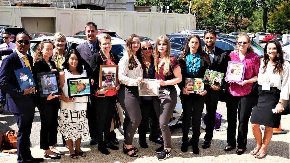 In 2019, Amber Rollins took parents from across the country to Washington, D.C., to advocate for passing a bill designed to prevent hot car deaths. The parents are shown with photos of their children who have died in hot cars.