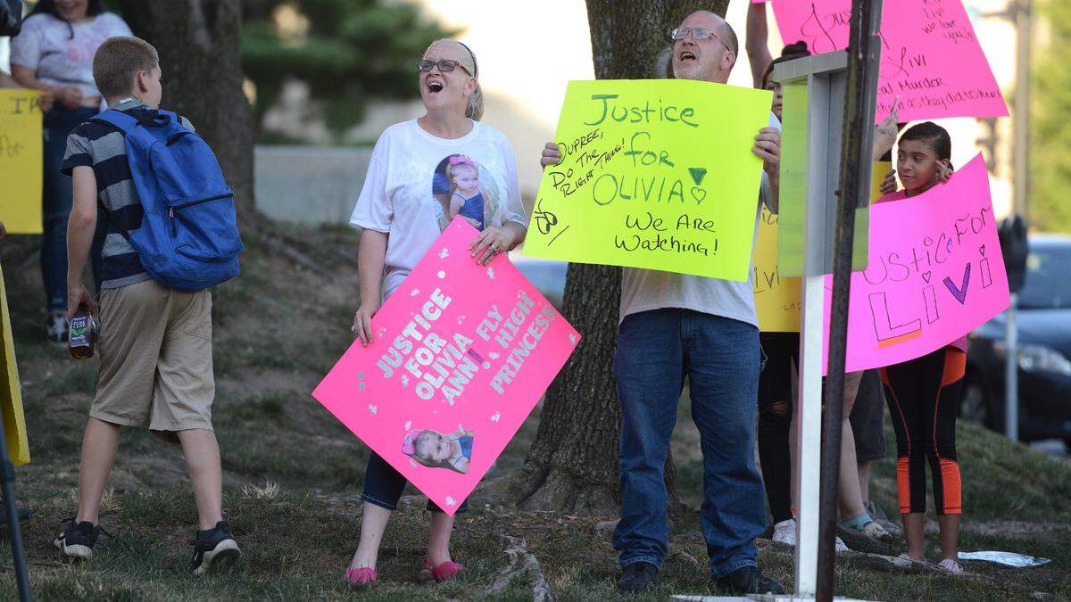 Elisabeth Jansen and Howard Jansen II call for justice for their granddaughter, Olivia, during a rally outside the Wyandotte County courthouse Sunday.