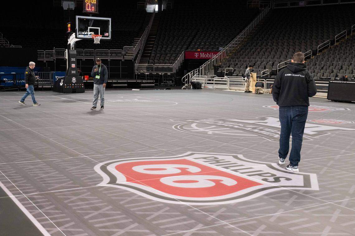 Employees of ASB GlassFloor test and finish installing the companies state-of-the-art glass LED basketball court, on Monday, March 2, 2026, at T-Mobile Center. The court, being used for the first time for a college basketball game, is controlled through a tablet which is capable of changing the look of the court at the press of a button.