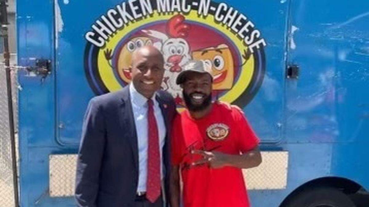 Kansas City mayor Quinton Lucas, left, visits Dyamund Shields Jr. at his food truck, Chicken Macaroni & Cheese. Shields was serving food from the truck at a gathering near Prospect Avenue when he was fatally shot early Monday morning.