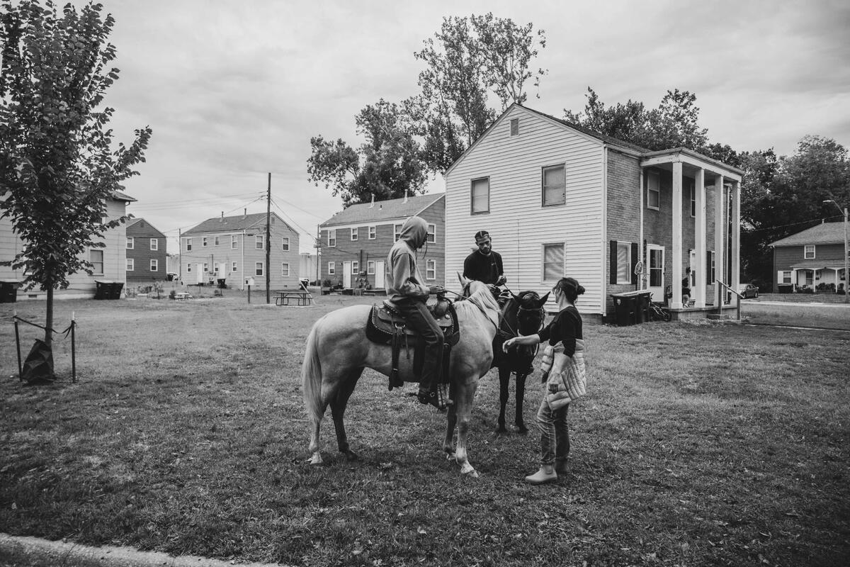 The Copper Boyz stop and chat with Denise Hart, president of the Holmes Garden Neighborhood Association, during a community outreach ride with KCPD in Kansas City.