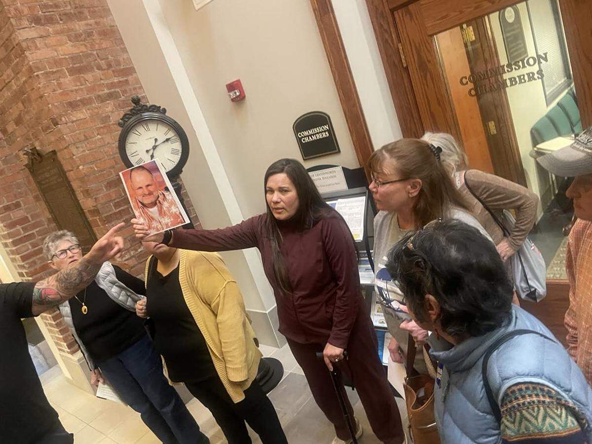Marcia Levring, a former CoreCivic prison guard, holds up a photo of Alan Hershberger. Levring and Hershberger worked together in Leavenworth, but he later transferred to another CoreCivic facility in Holdenville, Oklahoma, where he was fatally attacked by an inmate in 2022.