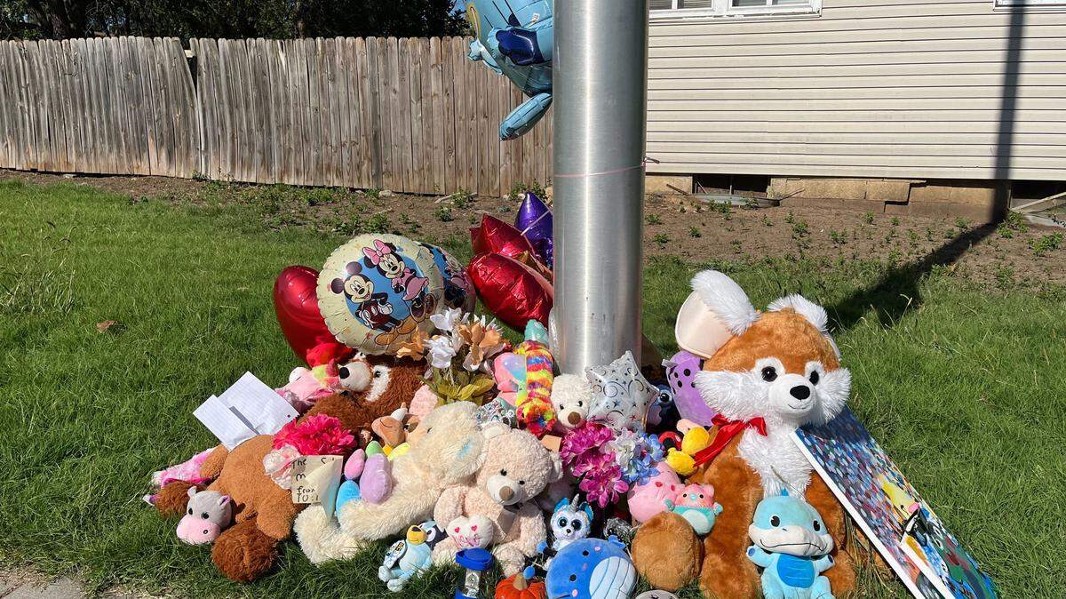 Flowers, notes, toys and balloons placed at a light post at the intersection where 3rd-grader Hazen Workman-Duffy was killed while biking to school Tuesday.