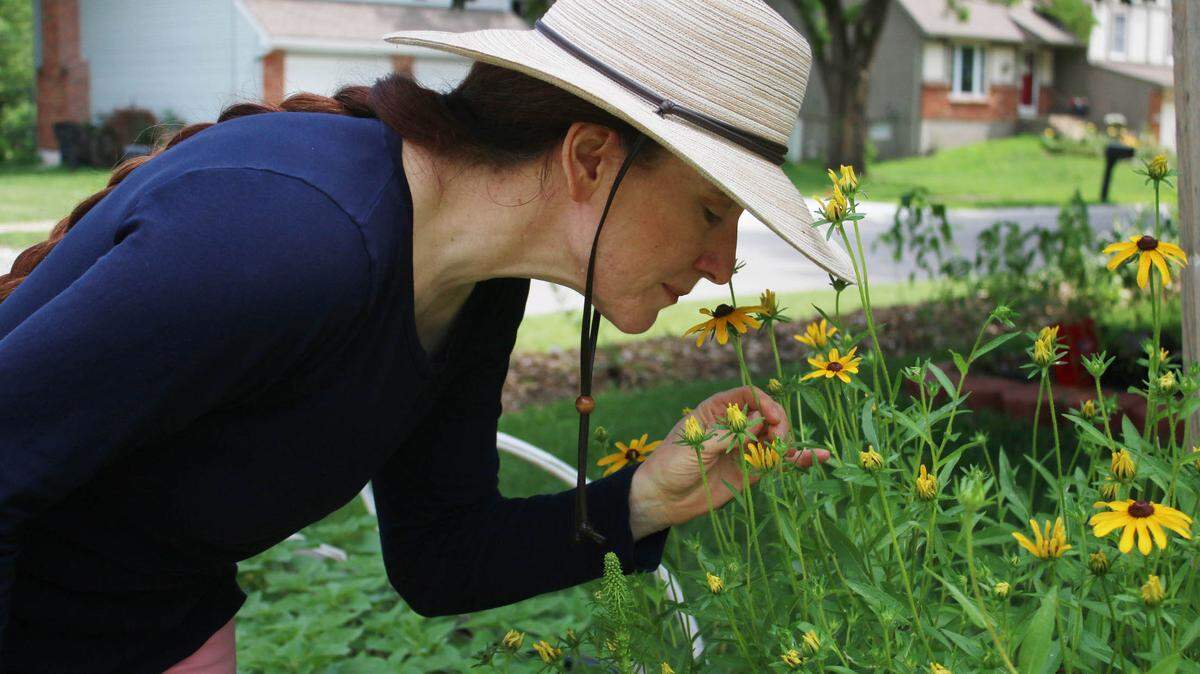 Dawn Bly sniffs some of the black-eyed Susans that make up part of My Front Yard Flower Farm. Bly started the business in 2022.