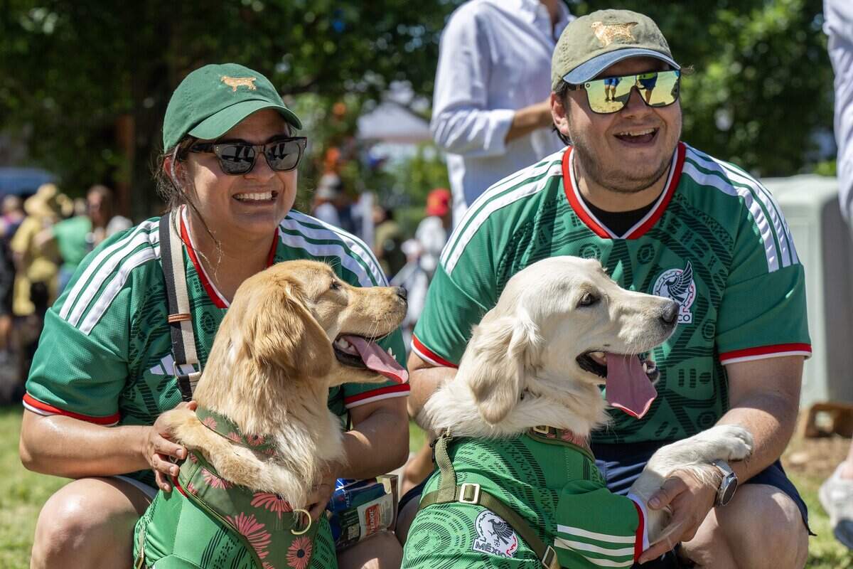 Alicia Rivera, left, and Francisco Franco, along with their dogs, Maika and Luna, all wear Mexico jerseys during Dog Day at the FIFA Fan Festival on Sunday, June 14, 2026, in Kansas City.