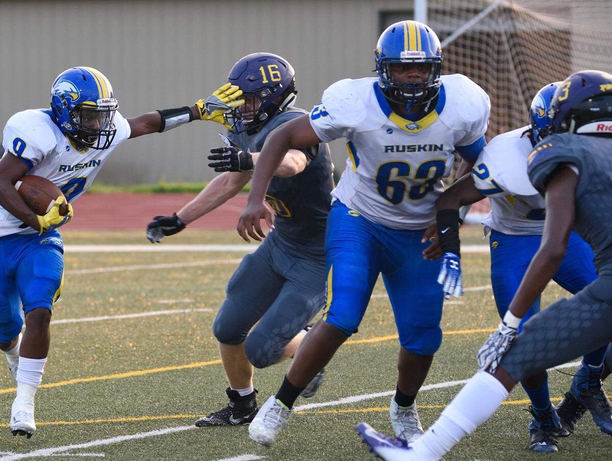 Aireontae Ersery, No. 63 in white, helps clear a path for the running back during a game last season.