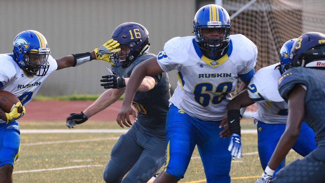 Aireontae Ersery, No. 63 in white, helps clear a path for the running back during a game last season.