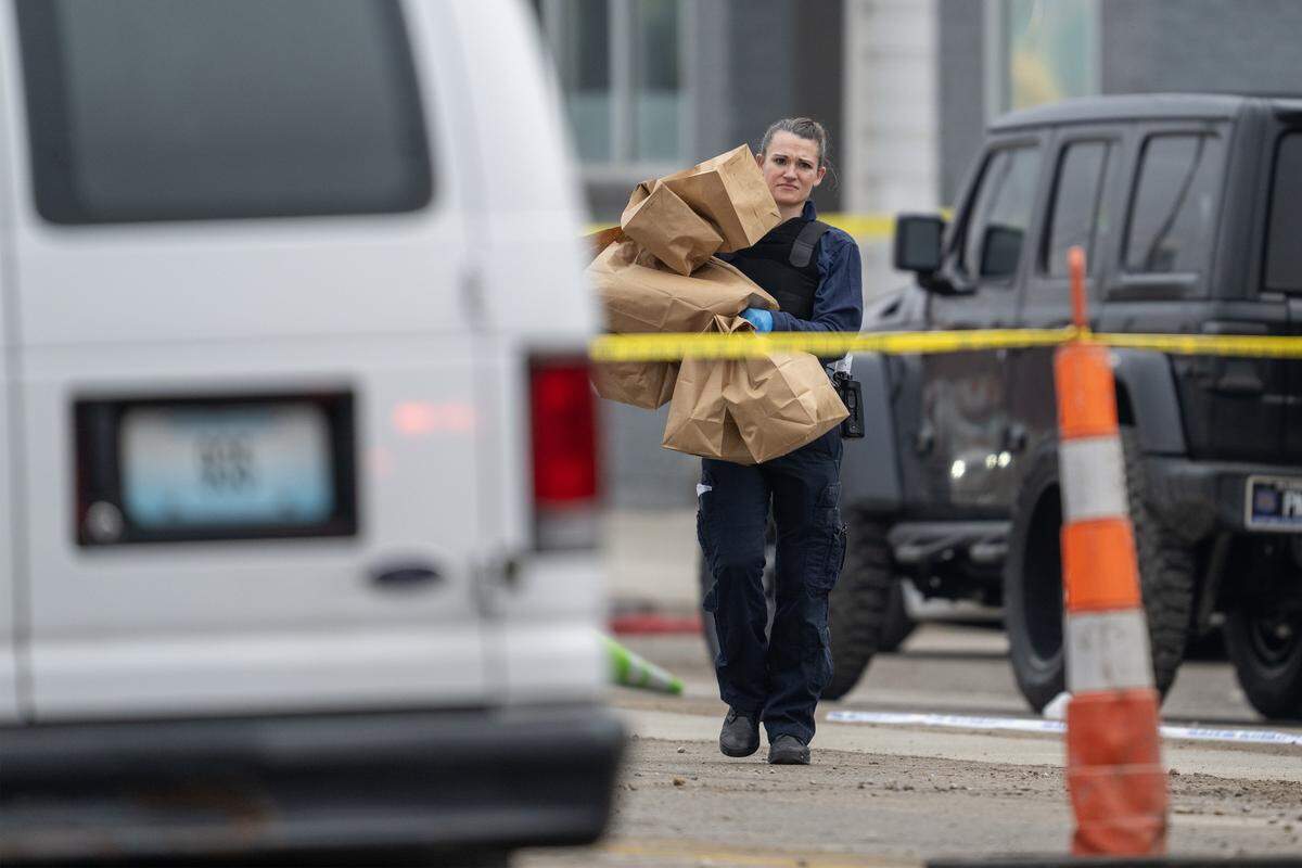 A Crime scene investigator from the Kansas City Police Department carries bags of evidence recovered from the scene of a shooting at a Kansas City nightclub, 2801 Southwest Blvd. on Sunday, Feb. 15, 2026. Two women were killed and two others injured during the incident. 