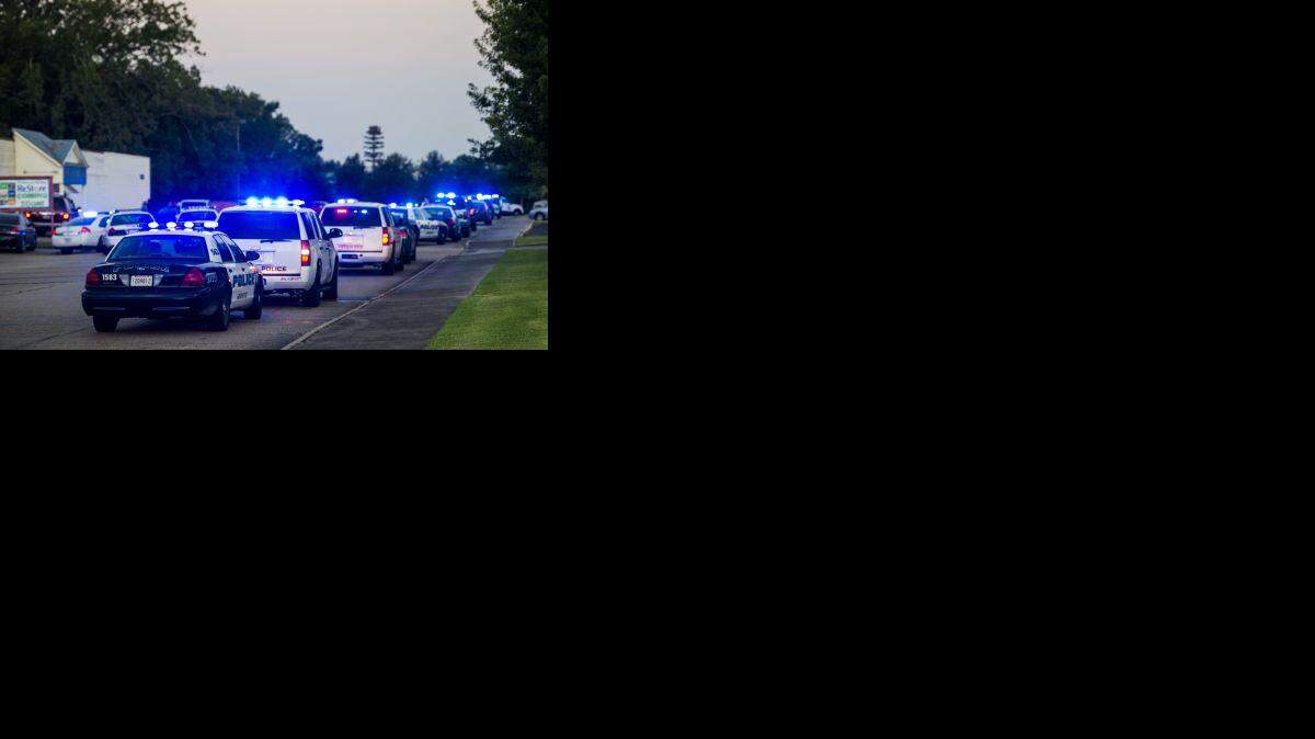 Lafayette Police Department and Louisiana State Police units block an entrance road following a shooting at The Grand Theatre in Lafayette, La., Thursday, July 23.
