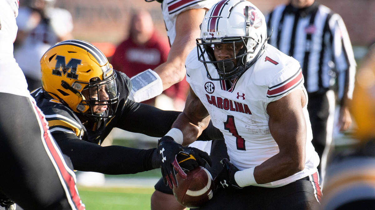 South Carolina running back MarShawn Lloyd, right, has the ball stripped by Missouri defensive lineman Isaiah McGuire, left, during the first quarter of an NCAA college football game Saturday, Nov. 13, 2021, in Columbia, Mo. (AP Photo/L.G. Patterson)