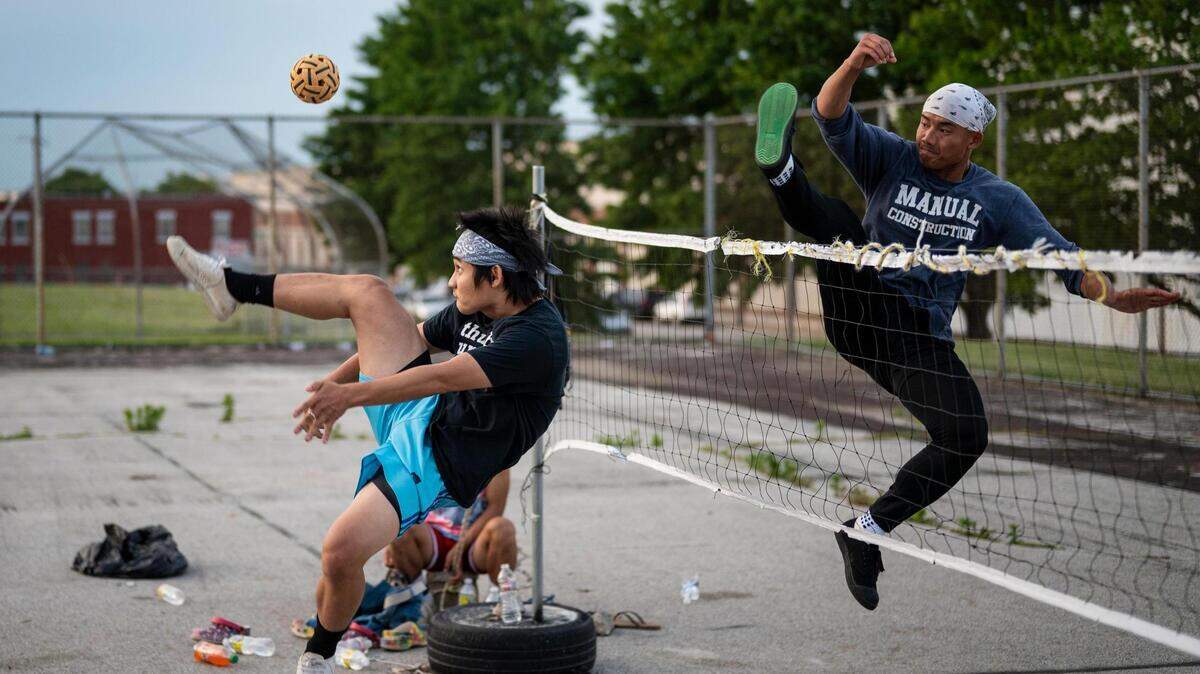 Htoo Lay kicks the ball and Lah Wah tries to block it as they play chinlone at Sheffield Park in Kansas City on June 5, 2022.