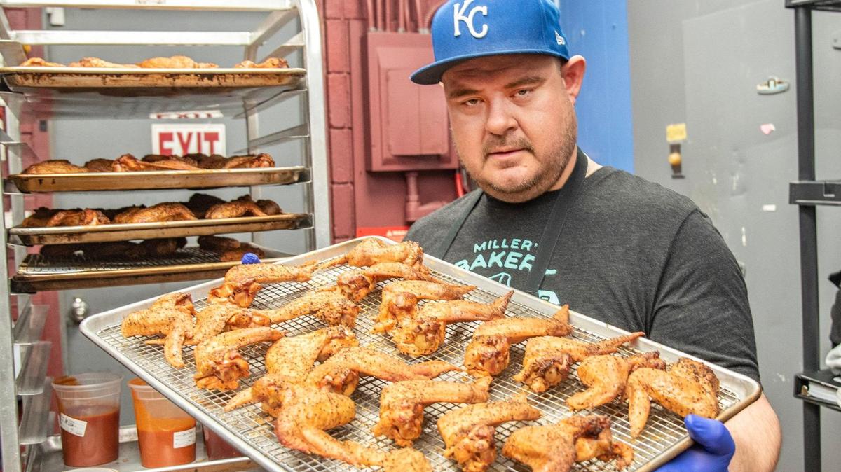Tyler Harp with a tray of wings ready for the oven.