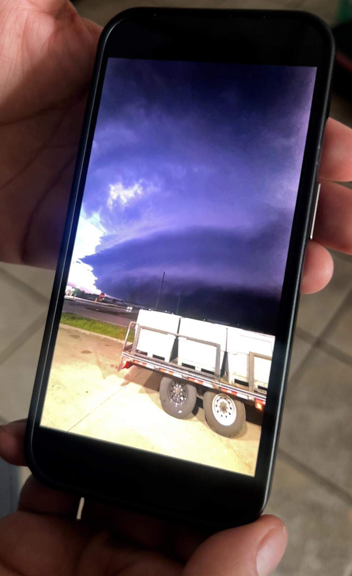 Asad Morani, owner of the Sunoco Lake-N-Dale convenience store, shows a photo on his phone that he took of the supercell storm moments before a tornado hit Hillsdale, Kansas, on Monday, April 13, 2026.
