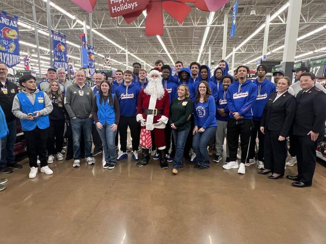 The KU basketball team poses for a photo at Walmart during the annual evening of shopping for families in need.