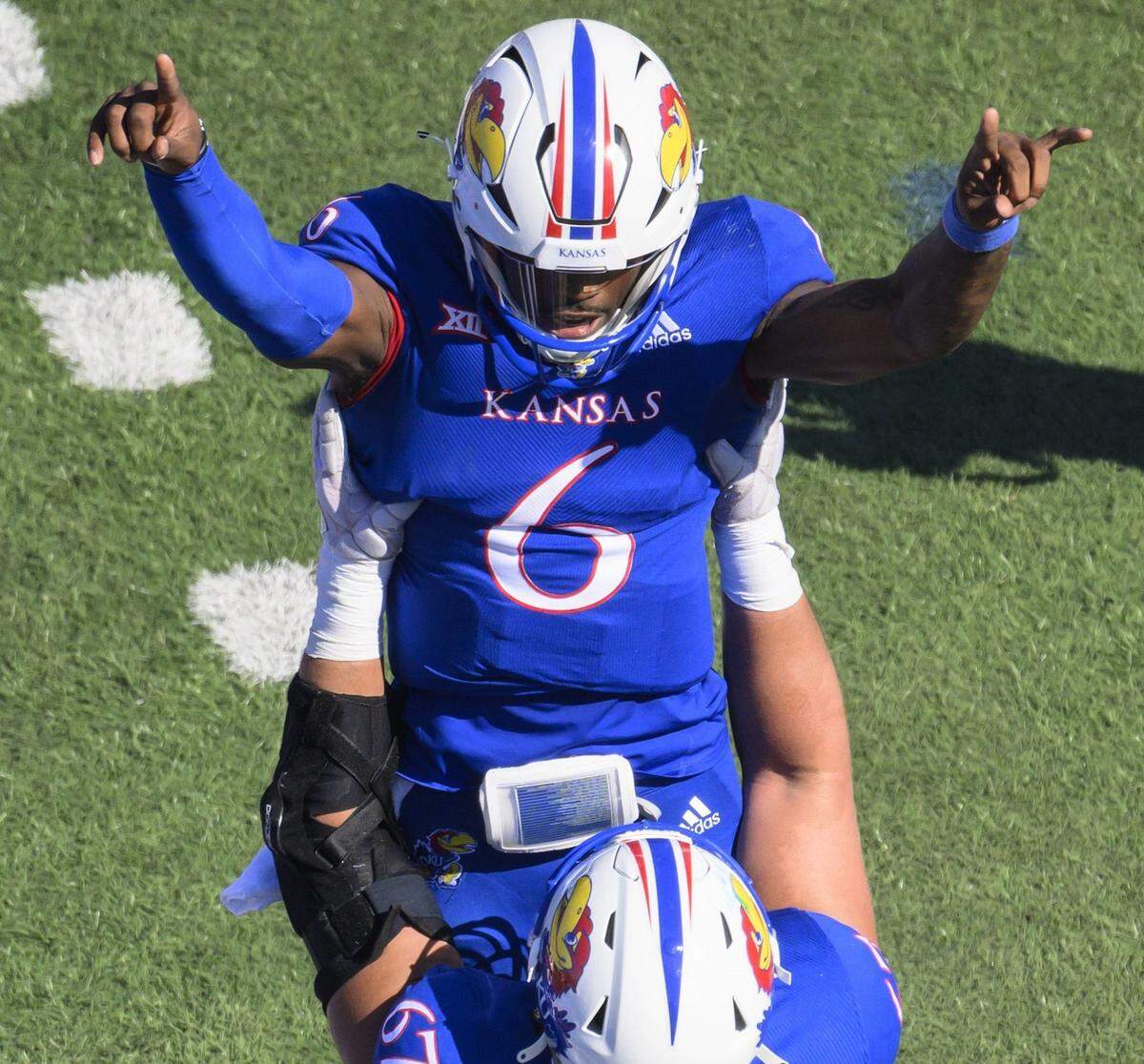 Kansas quarterback Jalon Daniels (No. 6) celebrates his touchdown against Iowa State with teammate lineman Dominick Puni last Saturday in Lawrence.
