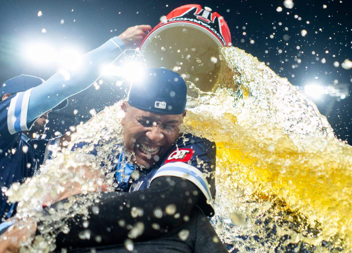 Kansas City Royals first baseman Salvador Perez (13) hugs reporter Joel Goldberg as he is doused by outfielder MJ Melendez (1) after defeating the Texas Rangers at Kauffman Stadium on May 3, 2024.