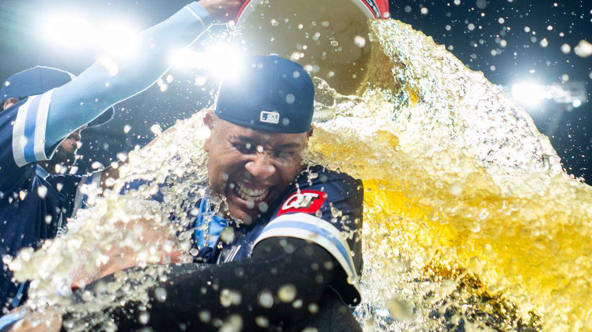 Kansas City Royals first baseman Salvador Perez (13) hugs reporter Joel Goldberg as he is doused by outfielder MJ Melendez (1) after defeating the Texas Rangers at Kauffman Stadium on May 3, 2024.