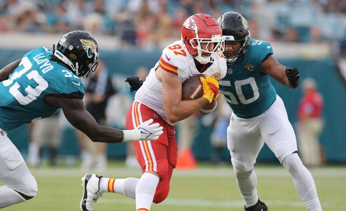 Jacksonville Jaguars linebacker Devin Lloyd (33) and defensive end Trevis Gipson (50) move in to make the tackle on Kansas City Chiefs tight end Travis Kelce (87) during first quarter action.